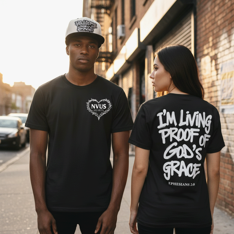 Two people wearing black t-shirts with text, standing on a street.