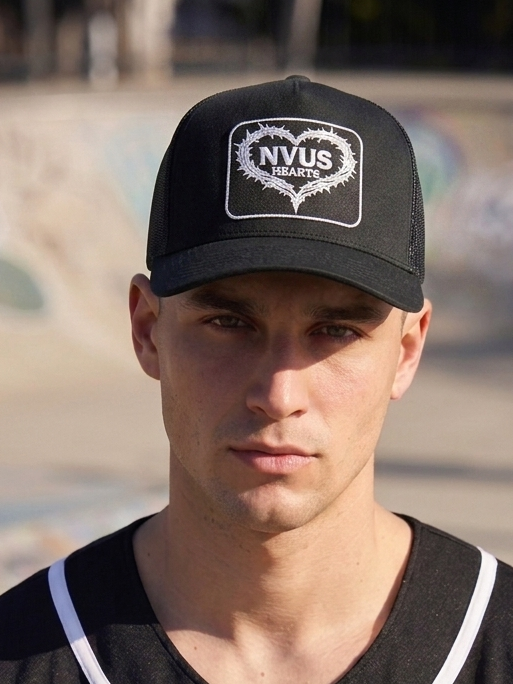 Person wearing a black cap and black jersey with 'NVUS HEARTS' logo at a skate park.