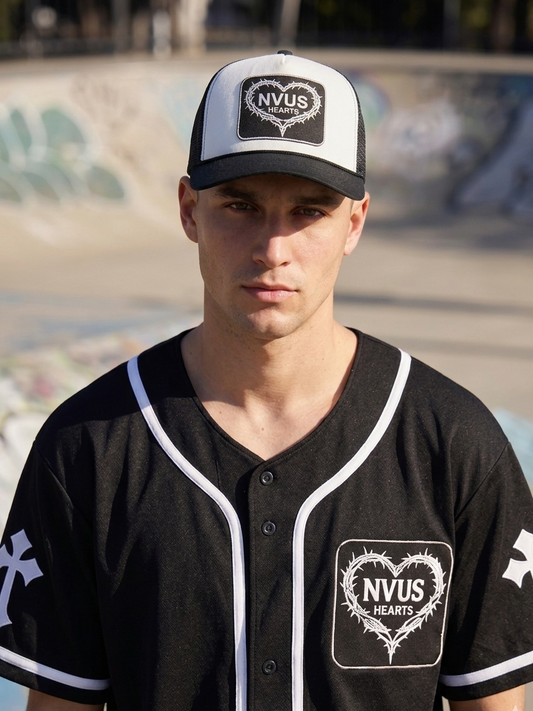 Person wearing a black baseball jersey and cap with 'NVUS' branding in an outdoor setting.