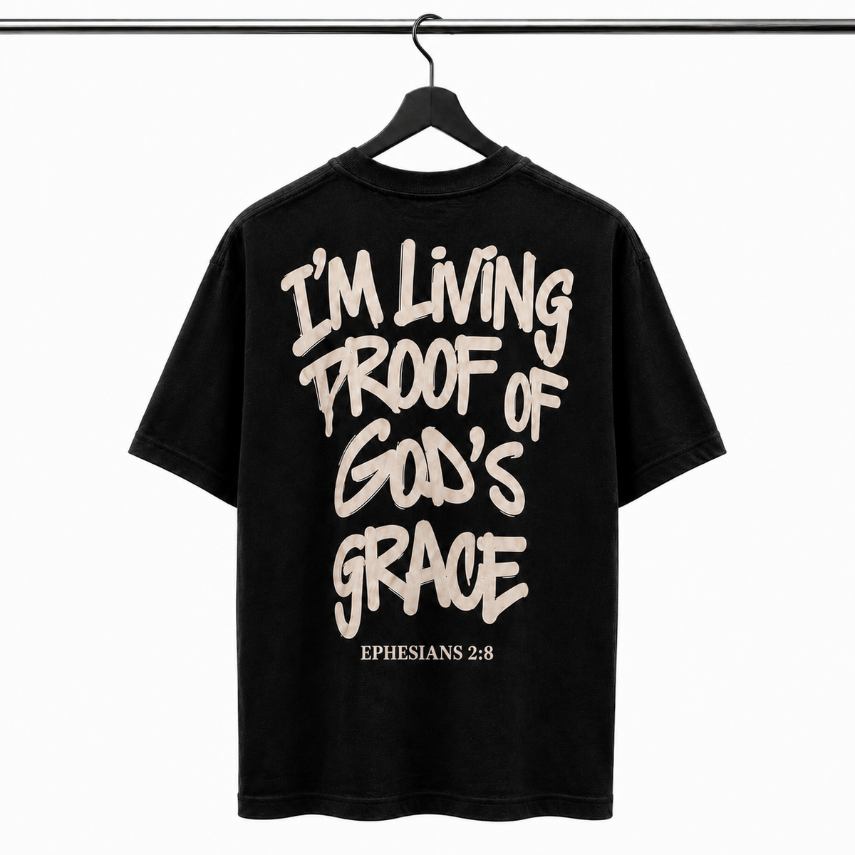 Black t-shirt with white text 'I'm Living Proof of God's Grace Ephesians 2:8' on a hanger against a white background
